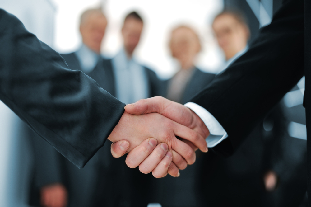 Handshake in front of business people-1